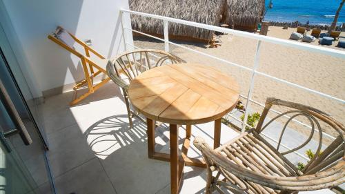 a wooden table and two chairs on a balcony at qema Mancora in Máncora