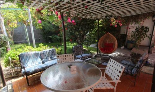 a patio with a table and chairs under a pergola at NEW Hotel Casa del Profesor in Iquique