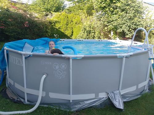 a woman is laying in a pool in a inflatable at Chambre ravissante, piscine et confort d'une maison in Les Bois