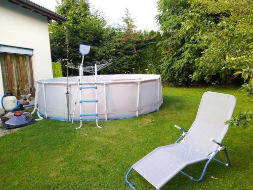 a hot tub and a chair in a yard at Chambre ravissante, piscine et confort d'une maison in Les Bois