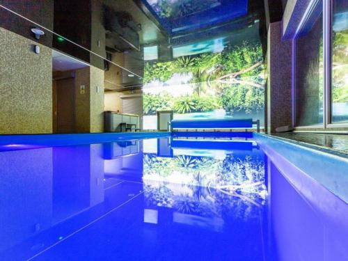 a swimming pool with a aquarium in a building at WYDMA Resort Medi & SPA - Normobaria in Mrzeżyno