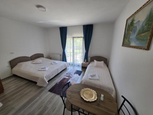a room with two beds and a table in it at NP Luxury Apartments in Novi Pazar
