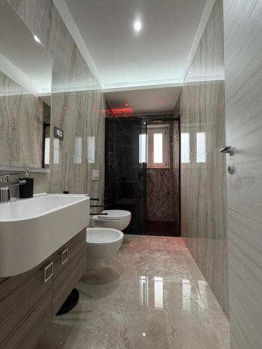 a bathroom with a tub and a sink and a toilet at Tropea Olympus Apartments in Santa Domenica