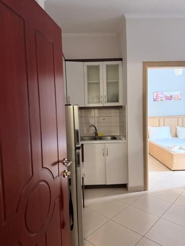 a kitchen with a refrigerator and a bed in a room at Borsh Grove Villa in Borsh