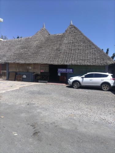 a white car parked in front of a building at Mtomo vision in Mtwapa