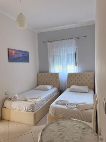 a bedroom with two beds and a window at Borsh Grove Villa in Borsh