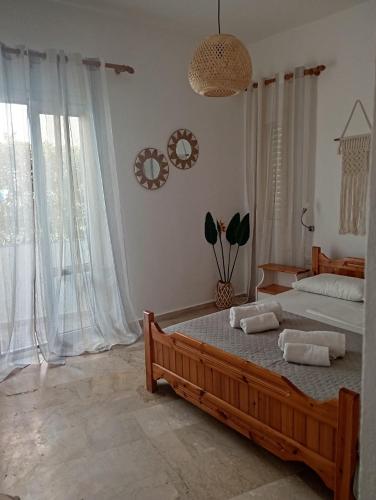 a bedroom with two beds and a large window at Spacious Apartment Garden View Partial Seaview in Makry Gialos
