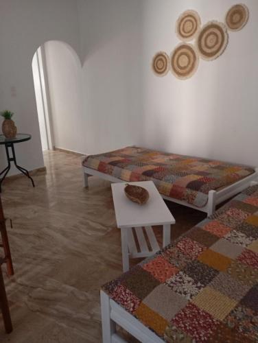 a living room with two beds and a table at Spacious Apartment Garden View Partial Seaview in Makry Gialos