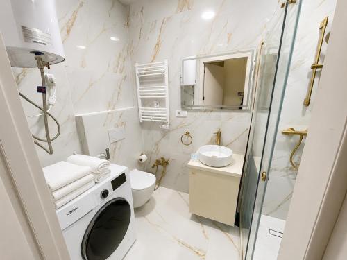 a white bathroom with a toilet and a sink at Mar y Sol in Batumi