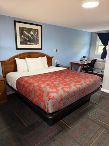 a bedroom with a large bed with a red blanket at Chaplin Inn & Suites in Chaplin