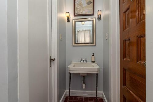 a bathroom with a sink and a mirror at 1895 Victorian Home on Historic Walnut Street in Springfield