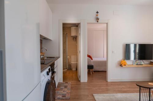 a kitchen with white walls and a kitchen with a table at Casa Naranjo - Plaza Mayor Almagro in Almagro