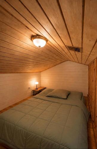 a bedroom with a large bed with a wooden ceiling at Le KOZY, LULU, FAR FAR in Saint-Joseph