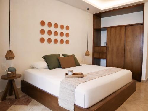 a bedroom with a large white bed with a wooden headboard at La Palma Beachfront Hotel Boutique in Cancún