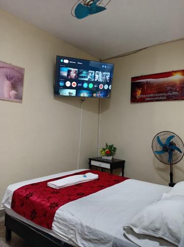 a bedroom with a bed with a flat screen tv on the wall at Hotel Resident Piura in Piura