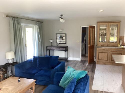 a living room with a blue couch and a table at Tarn View in Winster