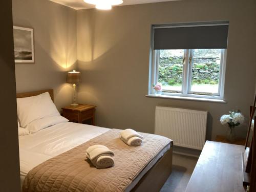 a bedroom with a bed with two towels on it at Tarn View in Winster