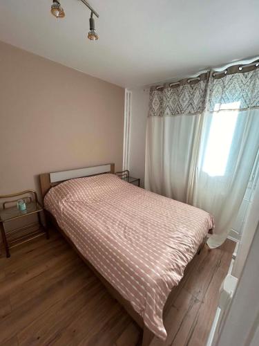 a small bedroom with a bed and a window at Happy Beautiful Home in Cholet