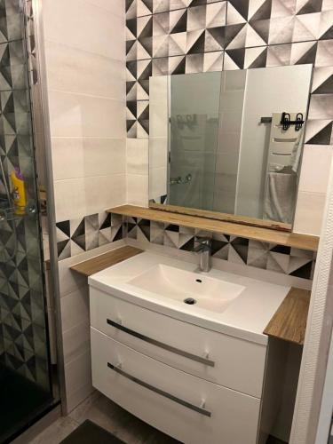 a bathroom with a sink and a mirror at Happy Beautiful Home in Cholet