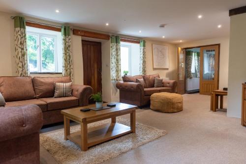 a living room with couches and a coffee table at The Barn - Old Mill Cottages in Ilfracombe
