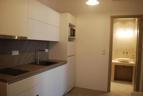 a kitchen with white cabinets and a sink at Busho Residence 1 in Naousa