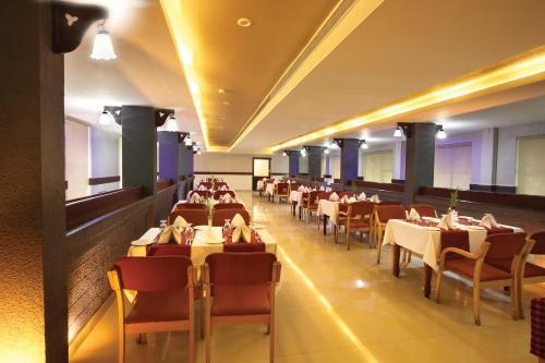 una sala da pranzo con tavoli e sedie di Hotel Virad a Kottakkal