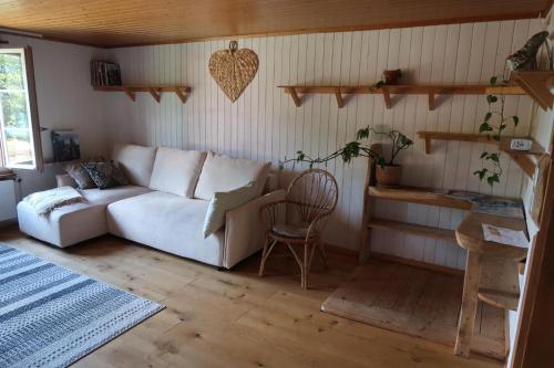 a living room with a white couch and a chair at Lakeview Chalet 1 , Drligen in Därligen