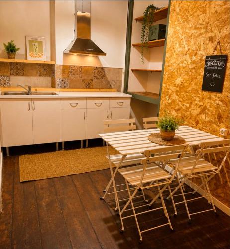 a kitchen with a table and chairs and a sink at Ria Surf & Stay in Faro