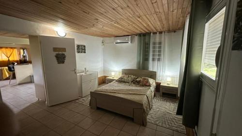 a small bedroom with a bed and a bathroom at La Maison Du Bonheur in Capesterre-Belle-Eau