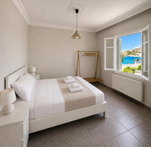 a bedroom with a bed and a large window at Araucaria Beachfront Residence in Finikas