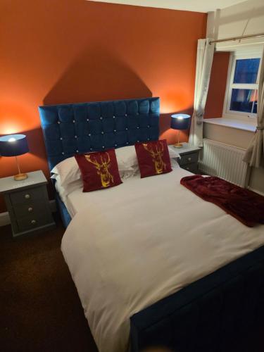 a bedroom with a large bed with red pillows at The Elks Head Inn in Whitfield