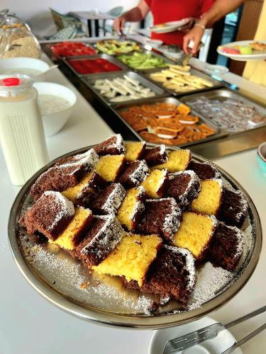 a table with a plate of brownies and other desserts at Valmar Hotel in Ksamil