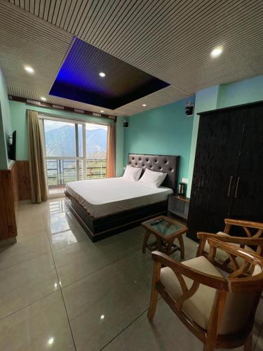 a bedroom with a bed and a large window at Laxman Homestay in Sarāhan