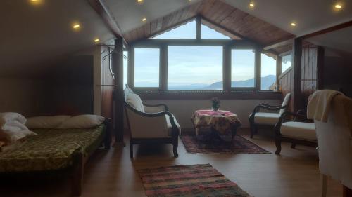 a room with a table and chairs and a large window at Hacel's Stairs in Ordu