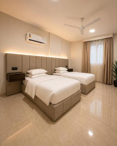 a hotel room with two beds and a window at ملاذ للشقق المخدومة in Salalah