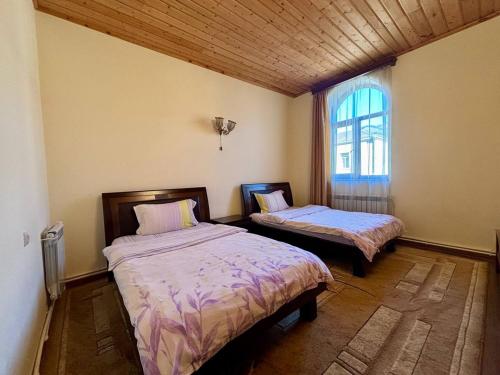 ein Schlafzimmer mit zwei Betten und einem Fenster in der Unterkunft Christy Hotel in Goris