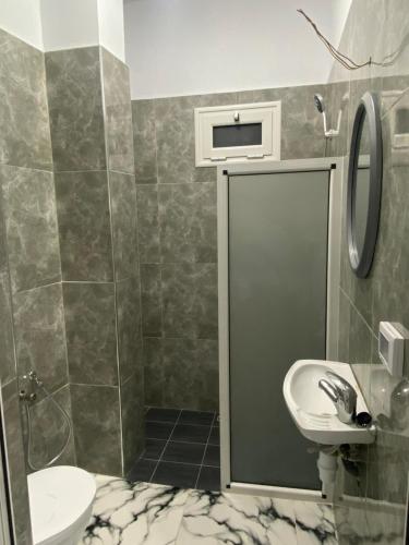 a bathroom with a shower and a toilet and a sink at Villa pamplemousse in Banī ‘Aţāʼ