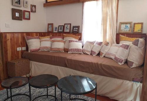 a bedroom with a bed with pillows and two tables at Rimbud guest house in Hārer