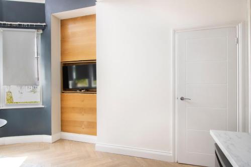 a white door in a room with a television at London Studios and Suites in Harrow