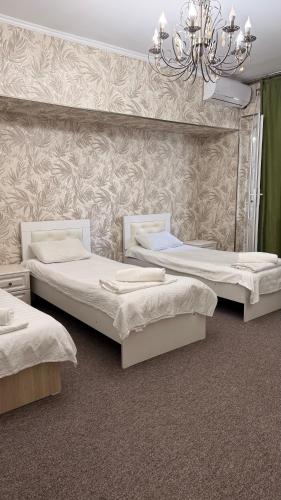 a room with three beds and a chandelier at Абдрахманова 176 in Bishkek