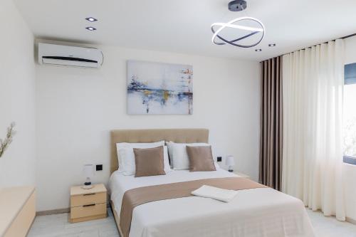 a white bedroom with a bed and a window at Villa MONTE Ulcinj in Stegvaši