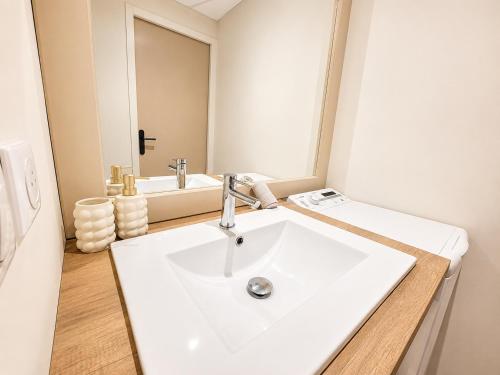 a bathroom with a white sink and a mirror at La Maison De Colette in Lezoux