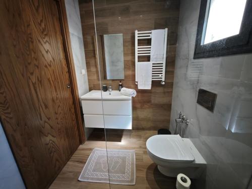 a bathroom with a white toilet and a sink at Palm Paradise in Sukrah