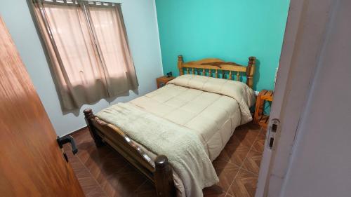 a small bed in a room with blue walls at Los 3 Gurises in Gualeguay