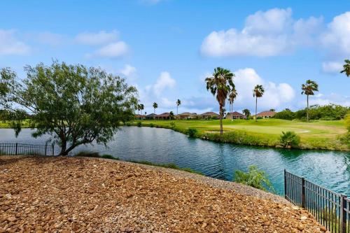 a golf course with a river and palm trees at Golden Palms in Laguna Vista