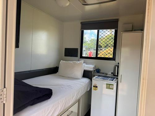 a small room with a bed and a window at Camden Holiday Park in Camden