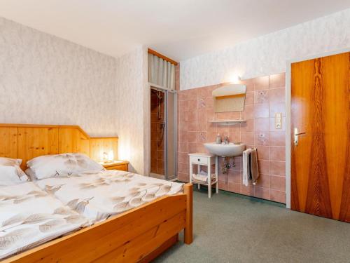 a bedroom with a large bed and a sink at Nussbaumer S in Niedernsill