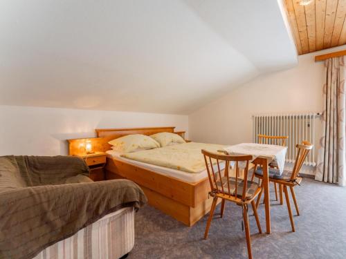 a bedroom with a bed and a table and chairs at Nussbaumer in Niedernsill