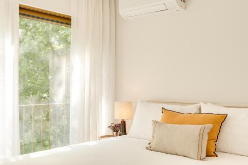 a white bedroom with a bed and a window at Matosinhos in Matosinhos
