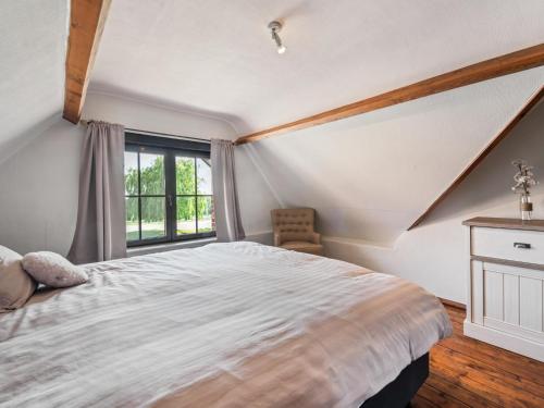 a bedroom with a large bed and a window at Rozenberghoeve in Ploegsteert